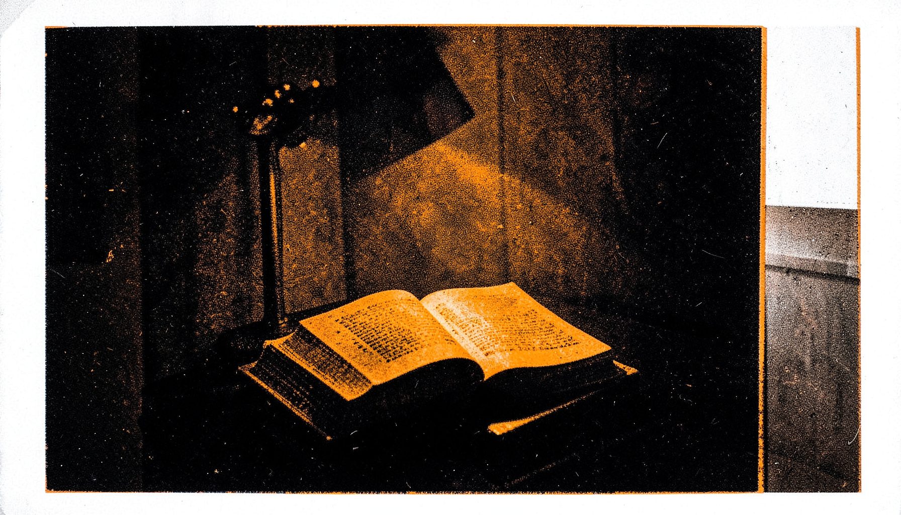 A two-ink risograph print in black and warm amber, depicting a quiet reading nook with soft golden lamplight spilling across an open book on a dark table, calm and contemplative.